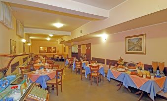 a large dining room with multiple tables and chairs arranged for a group of people to enjoy a meal together at Hotel Majestic