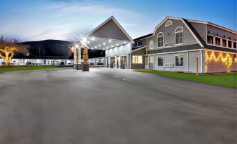 a large building with a parking lot in front of it , illuminated by lights at night at Top Notch Inn