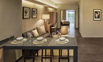 a modern dining room with a table set for two people , a couch , and a fireplace at Tropics Eight Suites