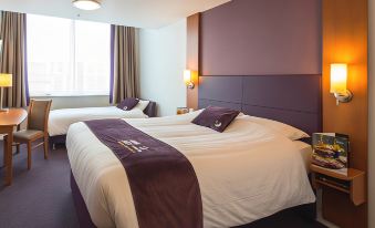 a hotel room with two beds , one on the left side and the other on the right side of the room at Premier Inn Dover East