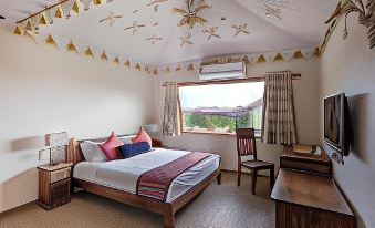 a cozy bedroom with a bed , desk , and chair , decorated with flags and stars on the ceiling at Serena Beach Resort