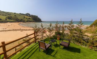 a balcony with two chairs and a table , overlooking a beautiful beach and ocean view at Hotel SanMar