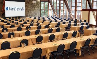 "a large conference room with rows of tables and chairs , a screen displaying "" valley airlines "" on the wall , and a sign in chinese characters" at The Village at Palisades Tahoe