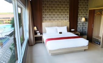 a large bed with a white comforter and red accent band is situated in a hotel room next to a window at Mexolie Hotel