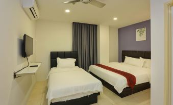 a hotel room with two beds , one on the left and one on the right side of the room at Havona Hotel - Kulai