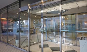 "a modern building with a large glass door and a sign that says "" canterbury united hotel .""." at Century Plaza Hotel