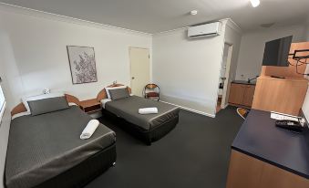 a hotel room with two beds , one on the left side of the room and the other on the right side at Boulevard Lodge Bundaberg