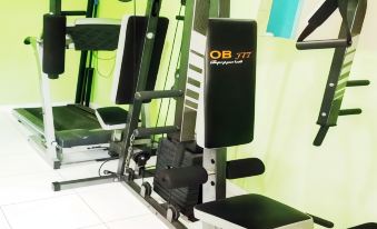 a gym with various exercise equipment , including treadmills and weight machines , in a well - equipped room at Bakom Inn Syariah