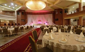 a large banquet hall with multiple tables and chairs set up for a formal event , possibly a wedding reception at Tunis Grand Hotel