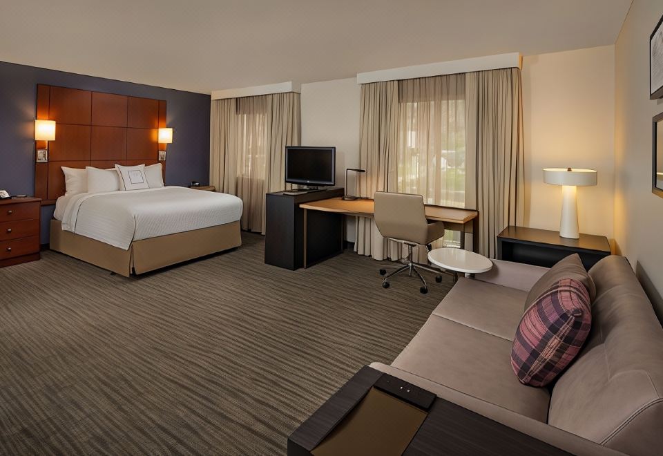 a hotel room with a king - sized bed , a desk , a chair , a television , and a desk at Sonesta ES Suites Nashville Brentwood