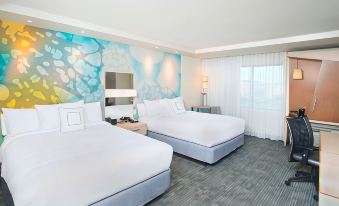 a hotel room with two white beds , one on the left and one on the right side of the room at Courtyard Redwood City