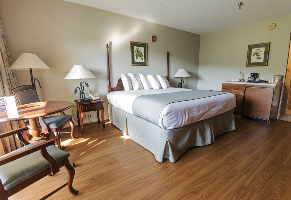 a large bed with a white comforter and two lamps on either side of it at Pine Mountain State Resort Park
