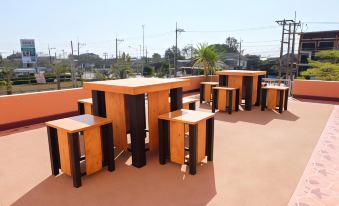 a rooftop area with several wooden tables and chairs , providing a pleasant outdoor space for socializing and socializing at Thatphanom View Hotel