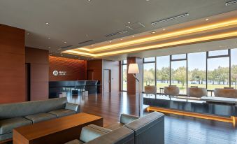 a modern office lobby with a reception desk and a large window overlooking the water at Rex Hotel Beppu