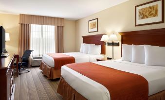 a hotel room with two beds , each made up with white linens and orange comforters , next to a window at Country Inn & Suites by Radisson, Baltimore North/White Marsh