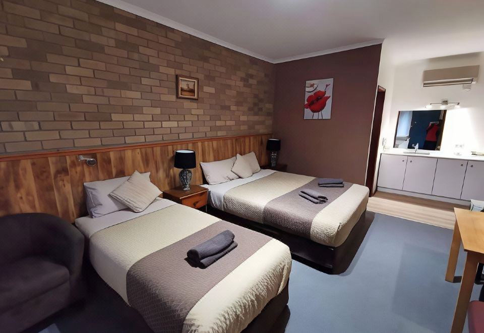 a hotel room with two beds , one on the left and one on the right side of the room at Peppinella Motel