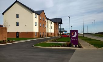 a brick building with a purple sign in front of it , situated on a street at Thirsk