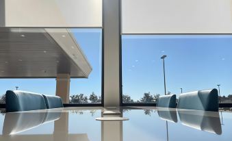 a conference room with large windows , blue chairs , and a view of the sky through the windows at Holiday Inn Express Big Rapids