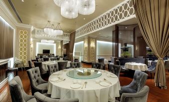 The dining room is furnished with tables and chairs, complemented by an ornate chandelier at Rio Hotel