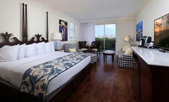 a large , well - appointed hotel room with hardwood floors , a king - sized bed , and a view of the ocean at Inn at Pelican Bay