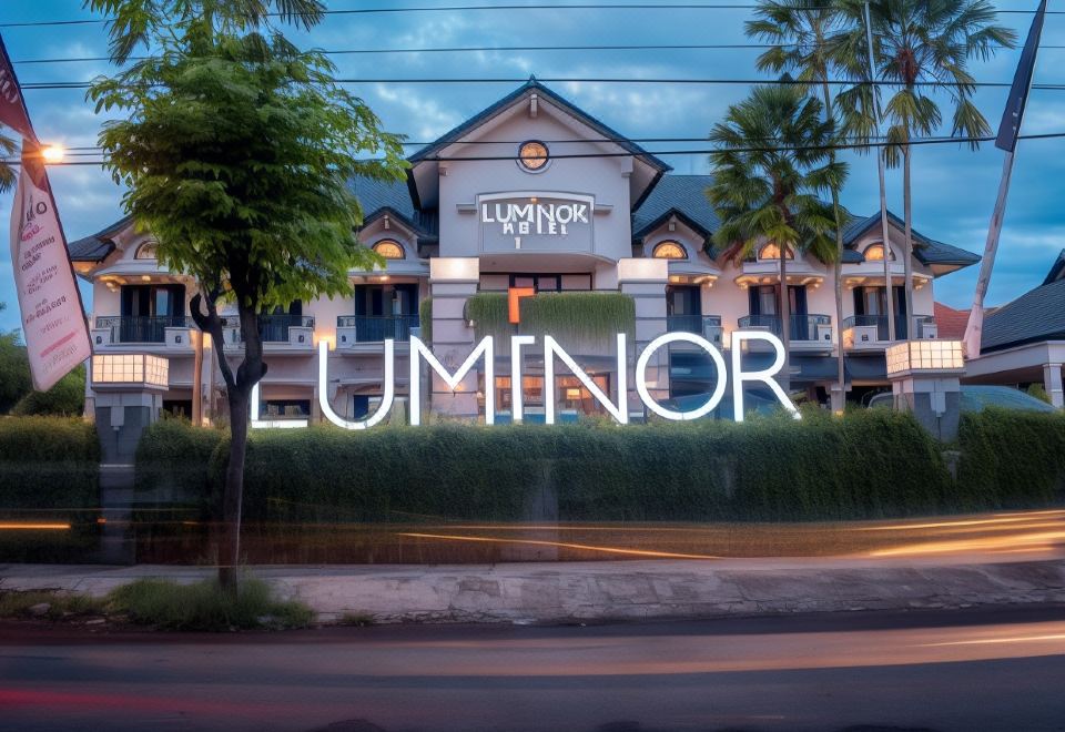 "a large building with a neon sign that says "" luminor hotel "" in front of it" at Luminor Hotel Jember by WH