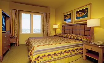 a hotel room with a king - sized bed , two lamps , and a window overlooking the ocean at Aquarius Vacation Club at Dorado del Mar