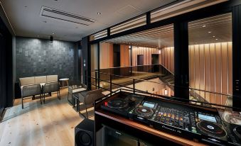 a room with a dj booth , chairs , and a piano , creating an entertaining space for music enthusiasts at Nohga Hotel Akihabara Tokyo