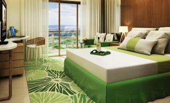 a luxurious hotel room with a green and white color scheme , featuring a large window offering a view of the ocean at Timberland Highlands Resort