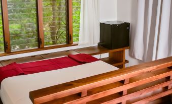 a bedroom with a wooden headboard and bed , featuring a red blanket on the bed at Aqua Nicaragua