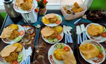 a dining table with a variety of food items , including chicken nuggets , fried chicken , and vegetables at Bakom Inn Syariah