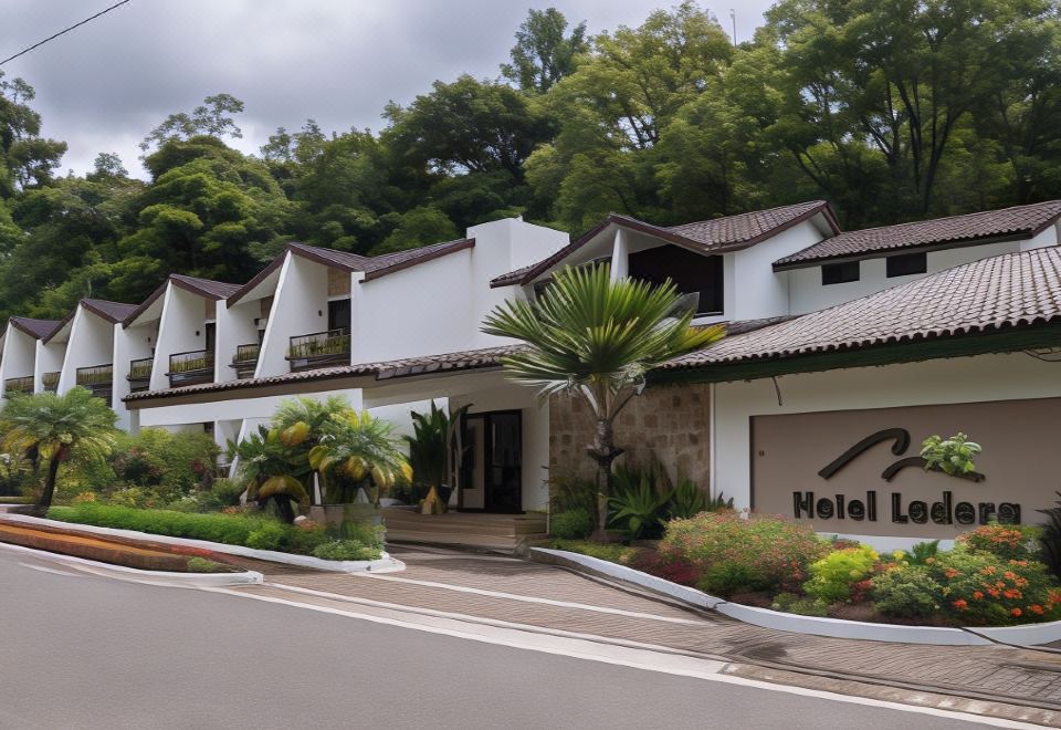 "a white building with a sign that reads "" hotel rinn "" is surrounded by greenery and trees" at Hotel Ladera