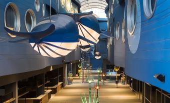 a modern building with large , blue whale - shaped lights hanging from the ceiling , creating an artistic and whimsical atmosphere at Beyond Patong