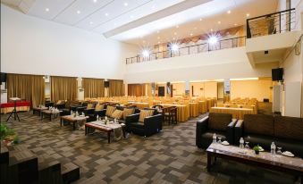 a large conference room with multiple tables and chairs arranged for a meeting or event at Grand Zuri Dumai