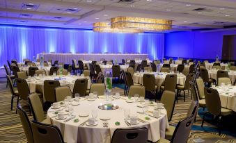 a large banquet hall with round tables covered in white tablecloths and chairs arranged for a formal event at Kahler Grand Hotel