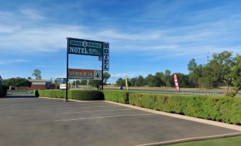 a motel sign in front of a hotel , with cars parked in front of it at Emerald Explorers Inn