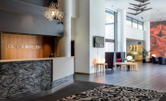 a modern hotel lobby with a large reception desk , seating areas , and a chandelier hanging from the ceiling at Quality Hotel Entry