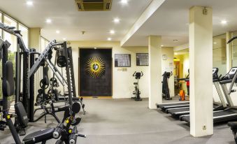 a well - equipped gym with various exercise equipment , including treadmills , weight machines , and a stationary bike at Grand Pasundan Convention Hotel