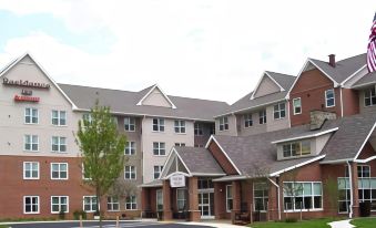 a large building with a brick facade and multiple balconies is shown from a low angle at Residence Inn Waldorf