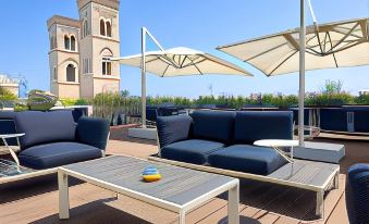 a rooftop patio with several lounge chairs , umbrellas , and tables set up for relaxation and socializing at Dogana Resort