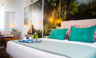 a modern bedroom with a large bed , green pillows , and a jungle mural on the wall at Thomar Boutique Hotel