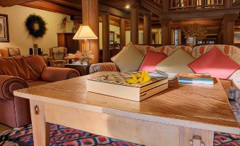 a cozy living room with wooden furniture , including a couch , chairs , and a coffee table at Daniels Summit Lodge