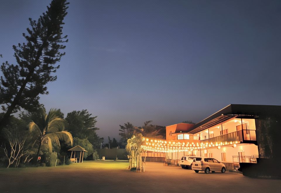 a large building with a lot of lights strung across it and palm trees in front of it at Borobudur Bed & Breakfast
