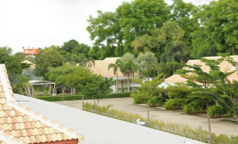 a residential area with houses surrounded by trees and grass , and a rooftop view of the landscape at Saraburi Garden Resort