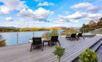 a wooden deck overlooking a body of water , with several chairs placed on the deck for relaxation at Beech Hill Hotel & Spa