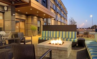 a patio area with a fire pit surrounded by couches and chairs , creating a cozy atmosphere at Home2 Suites by Hilton Gonzales