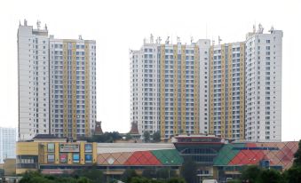 a modern city skyline with tall buildings and a shopping mall , set against a cloudy sky at Hotel Horison Grand Serpong