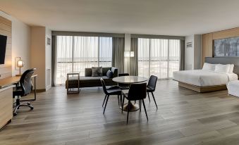 a modern hotel room with a large window , a dining table , chairs , and a couch at Mobile Marriott