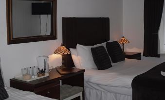 a hotel room with two beds , one on the left side of the room and the other on the right side at Richmond Hotel