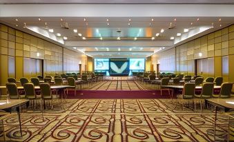 a large conference room with rows of chairs arranged in a semicircle , and a stage set up for a presentation at London Heathrow Marriott Hotel
