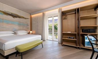 a modern bedroom with a large bed , wooden furniture , and sliding glass doors leading to a balcony at Hotel Firenze